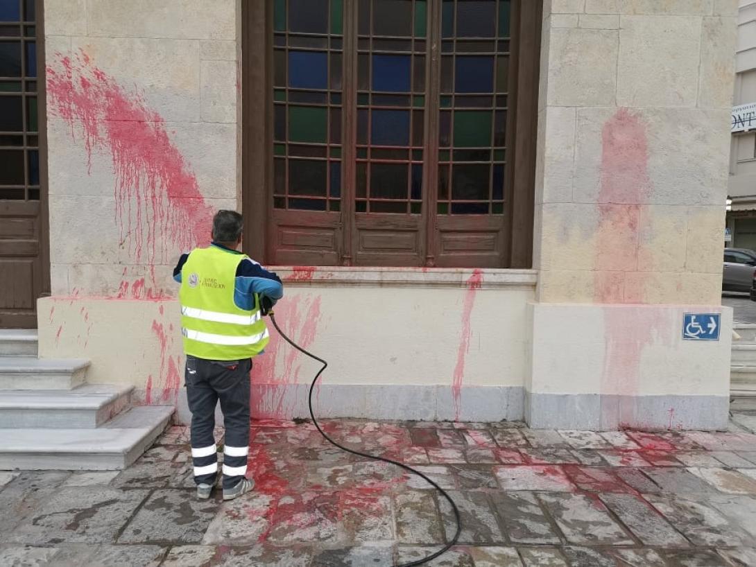 Υπάλληλος του Δήμου καθαρίζει την κόκκινη μπογιά που έριξαν οι βάνδαλοι.