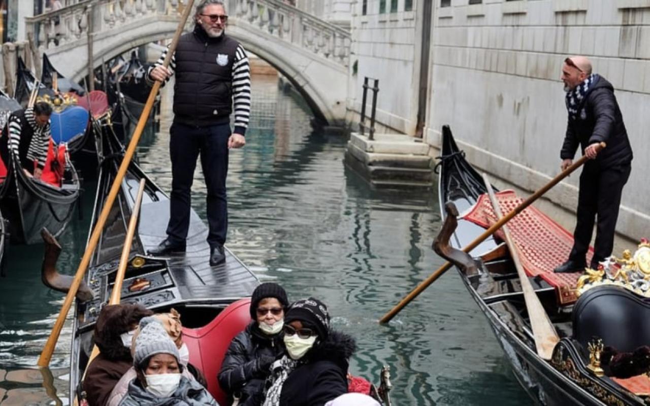 Τουρίστες με μάσκες, απολαμβάνουν τη βόλτα τους σε κανάλι της Βενετίας.