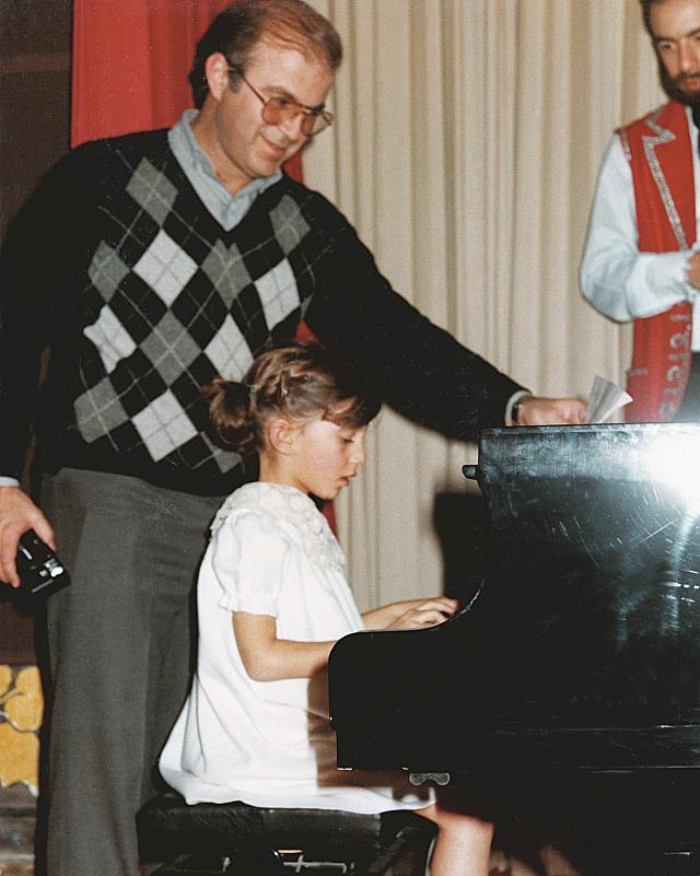 1982: Ο Νίκος Βερνίκος απολαμβάνει τα κάλαντα από την Ιζαμπέλα Κόβα στο πιάνο.