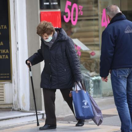 Με μια μάσκα στο πρόσωπο η κυρία της φωτογραφίας κάνει τα ψώνια της ημέρας.