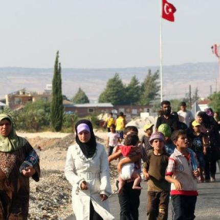 syrian-people-walk-near-the-border-with-turkey.jpg