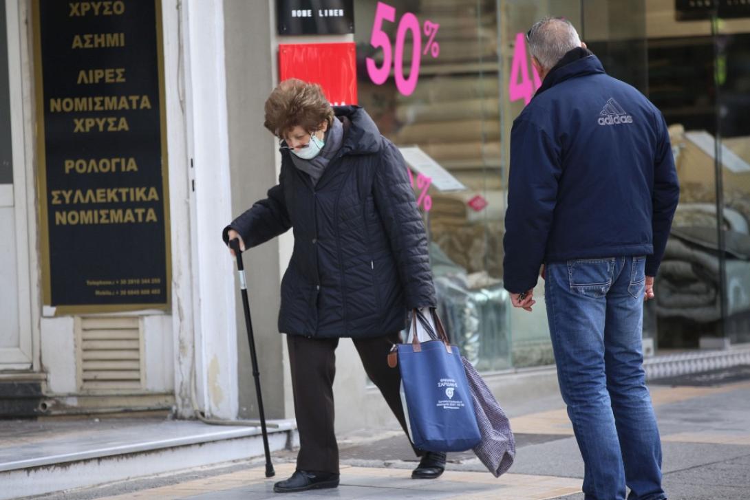 Με μια μάσκα στο πρόσωπο η κυρία της φωτογραφίας κάνει τα ψώνια της ημέρας.