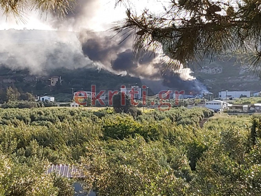 Δίπλα από εργοστάσιο βρίσκονται σπίτια και καλλιέργειες.